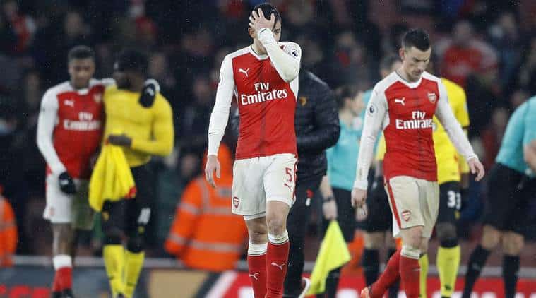 Dejected Arsenal players walk off the field after a defeat at the Emirates Stadium
