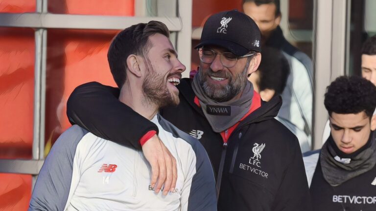 Former Liverpool captain Jordan Henderson receives an arm around the shoulder from manager Jurgen Klopp.