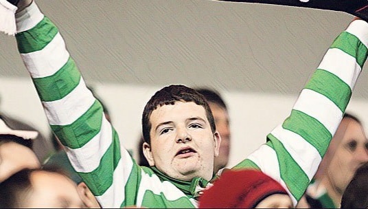 Comedian and Celtic fan Kevin Bridges holds up a scarf that says 