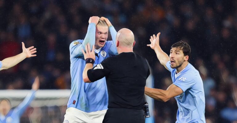 Referee Simon Hooper is surrounded by Erling Haaland, Mateo Kovacic and Ruben Dias after he stopped the game to award Manchester City a free kick and deny Jack Grealish (not pictured) the chance to play on and have a goal scoring chance during the Premier League match between Man City and Tottenham Hotspur at Etihad Stadium on December 03, 2023.
