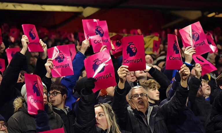 Everton fans hold up pink protest cards during the Premier League match between Nottingham Forest and Everton FC at City Ground on December 02, 2023 in Nottingham, England.