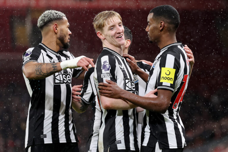 Alexander Isak of Newcastle United celebrates with team mate Anthony Gordon after scoring their side's first goal during the Premier League match between Liverpool FC and Newcastle United at Anfield on January 01, 2024 in Liverpool, England.