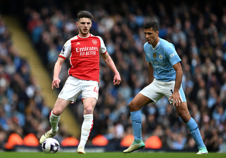 Declan Rice of Arsenal is challenged by Rodri of Manchester City during the Premier League match between Man City and Arsenal FC at Etihad Stadium on March 31, 2024 in Manchester, England.