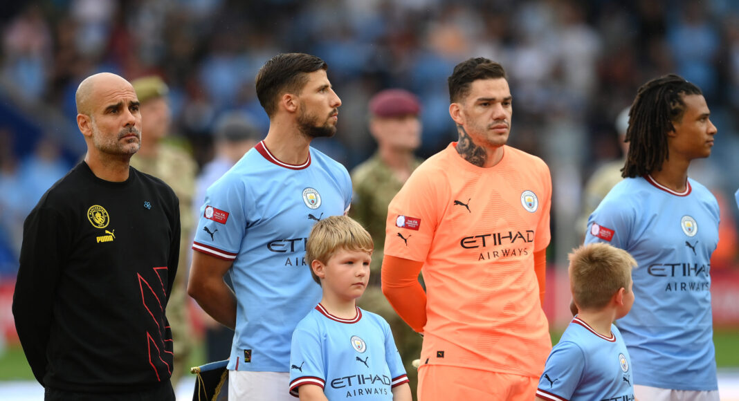 Pep Guardiola, Manager of Man City, Ruben Dias and Ederson of Manchester City line up during the National Anthems prior to kick off of The FA Community Shield between Premier League clubs Manchester City and Liverpool FC at The King Power Stadium on July 30, 2022 in Leicester, England.