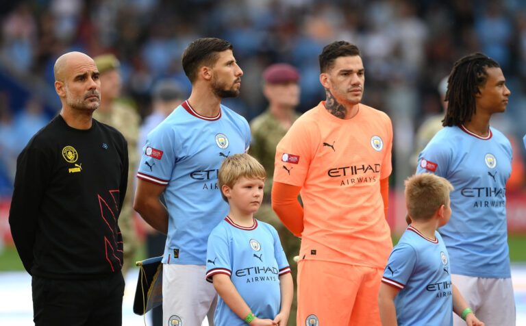 Pep Guardiola, Manager of Man City, Ruben Dias and Ederson of Manchester City line up during the National Anthems prior to kick off of The FA Community Shield between Premier League clubs Manchester City and Liverpool FC at The King Power Stadium on July 30, 2022 in Leicester, England.