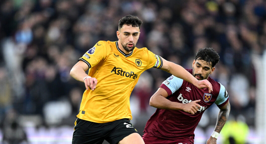Max Kilman of Wolverhampton Wanderers holds off Lucas Paqueta of West Ham United during the Premier League match between West Ham United and Wolves at London Stadium on December 17, 2023 in London, England.