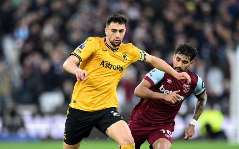 Max Kilman of Wolverhampton Wanderers holds off Lucas Paqueta of West Ham United during the Premier League match between West Ham United and Wolves at London Stadium on December 17, 2023 in London, England.