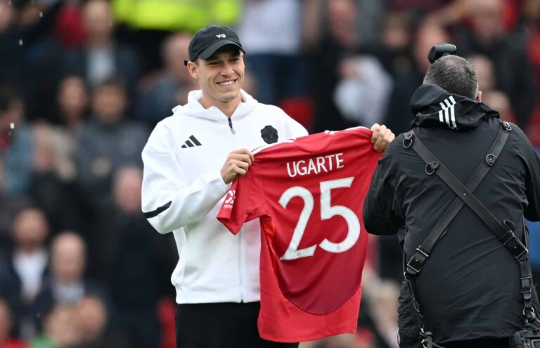 New signing, Manuel Ugarte of Manchester United, poses for a photo, as he holds up his shirt prior to the Premier League match between Manchester United FC and Liverpool FC at Old Trafford on September 01, 2024 in Manchester, England.