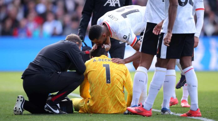 Alisson Becker of Liverpool is comforted by teammate Cody Gakpo as he receives medical treatment after an injury during the Premier League match between Crystal Palace FC and Liverpool FC at Selhurst Park on October 05, 2024 in London, England.