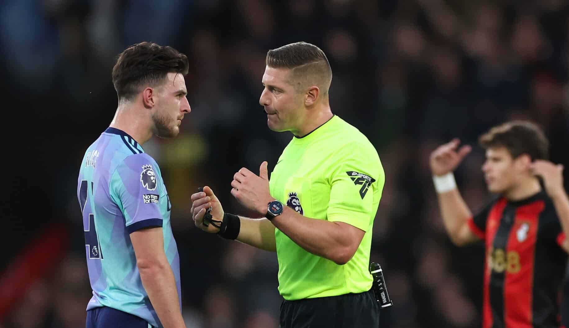 Match Referee, Robert Jones interacts with Declan Rice of Arsenal after showing a red card to his teammate, William Saliba (not pictured) during the Premier League match between AFC Bournemouth and Arsenal FC at Vitality Stadium on October 19, 2024 in Bournemouth, England.