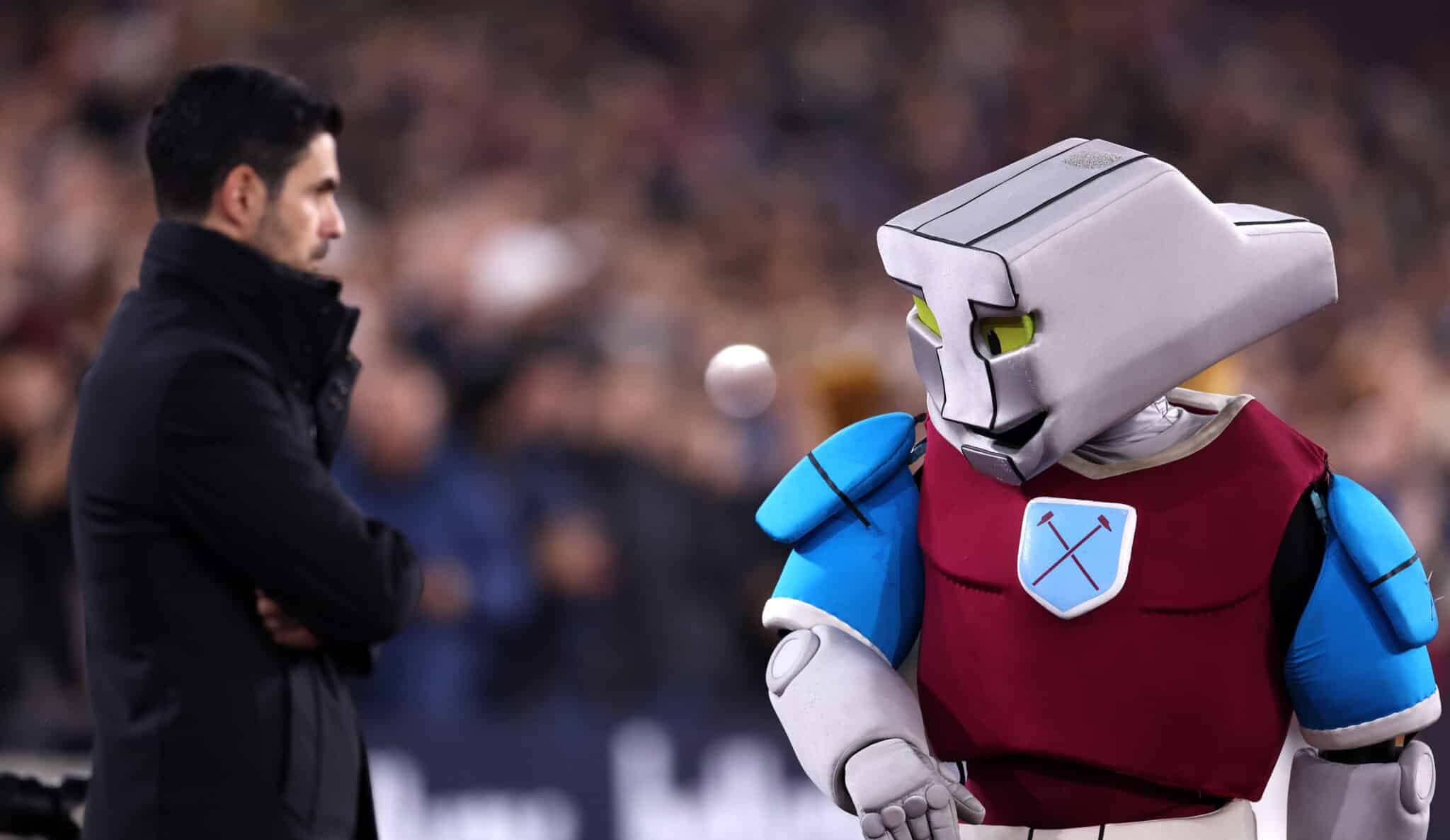 Arsenal manager Mikel Arteta looks on as Hammerhead, Mascot of West Ham United, walks past prior to during the Premier League match between West Ham United FC and Arsenal FC at London Stadium on November 30, 2024 in London, England.