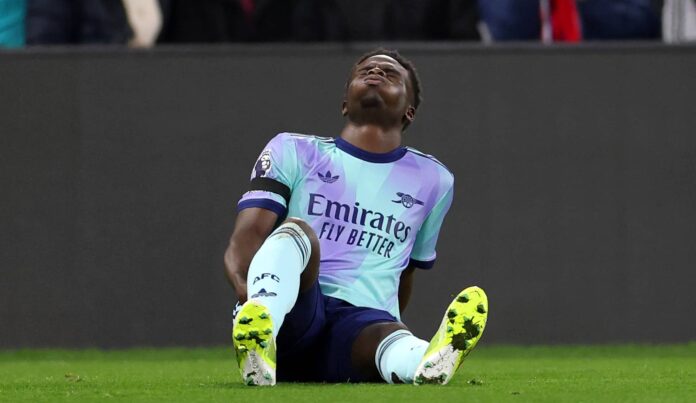 Bukayo Saka of Arsenal reacts after picking up an injury, before receiving medical treatment and later leaving the field, during the Premier League match between Crystal Palace FC and Arsenal FC at Selhurst Park on December 21, 2024 in London, England.