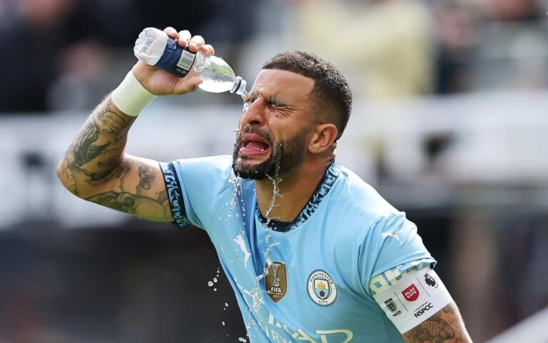 Kyle Walker of Man City pours a bottle of water over his face whilst wearing the captains armband during the Premier League match between Newcastle United FC and Manchester City FC at St James' Park on September 28, 2024 in Newcastle upon Tyne, England.