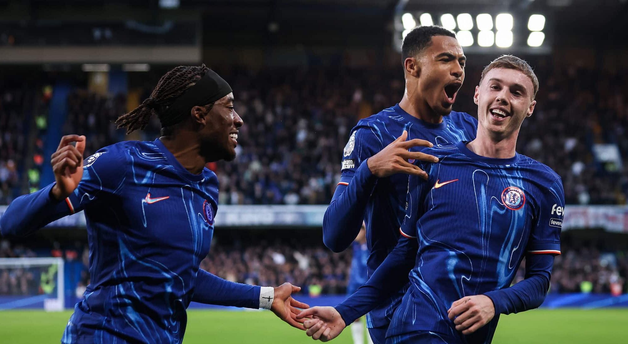 Cole Palmer of Chelsea celebrates scoring his team's third goal with Noni Madueke and Levi Colwill during the Premier League match between Chelsea FC and Aston Villa FC at Stamford Bridge on December 01, 2024 in London, England.
