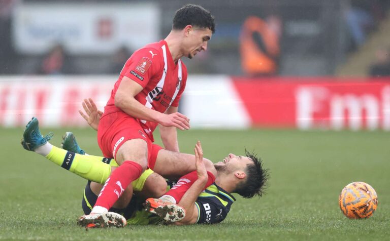 Nico Gonzalez of Manchester City is challenged by Sonny Perkins of Leyton Orient during the Emirates FA Cup Fourth Round match between Leyton Orient and Manchester City at Gaughan Group Stadium on February 08, 2025 in London, England.