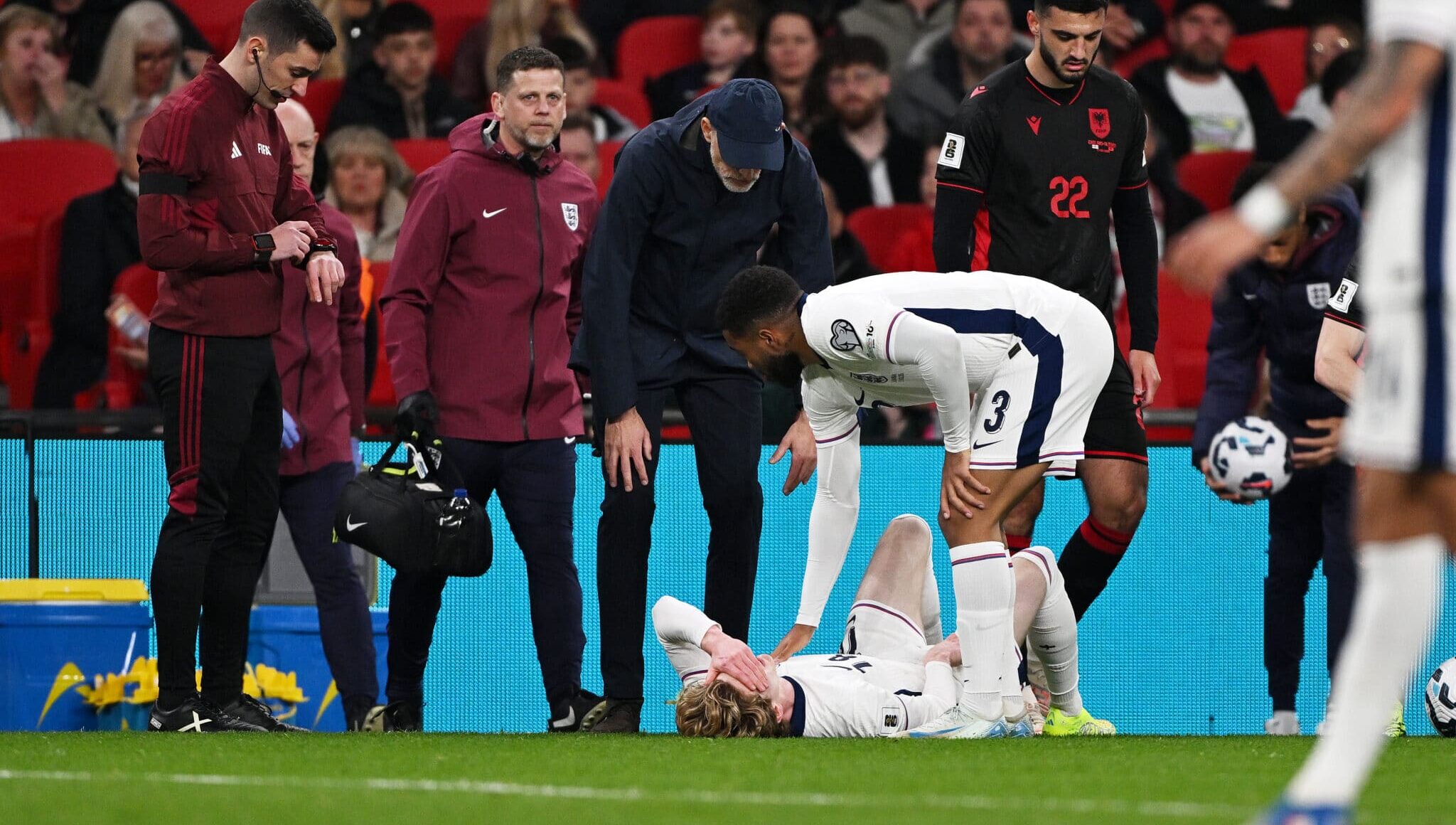 Anthony Gordon of England goes down with an injury and is checked on by manager Thomas Tuchel and teammate Reece James during the FIFA World Cup 2026 European Qualifier between England and Albania at Wembley Stadium on March 21, 2025 in London, England.