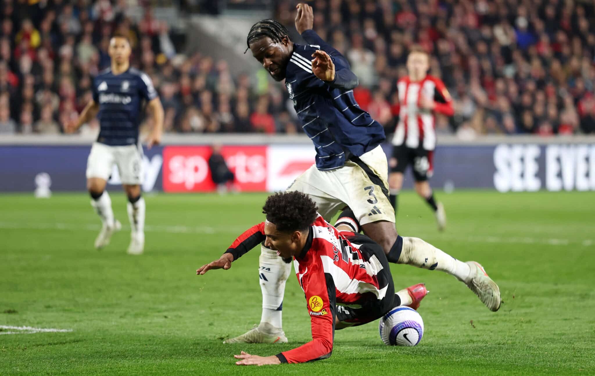 Brentford player Kevin Schade is challenged by Axel Disasi of Aston Villa during the Premier League match between Brentford FC and Aston Villa FC at Brentford Community Stadium on March 08, 2025 in Brentford, England.