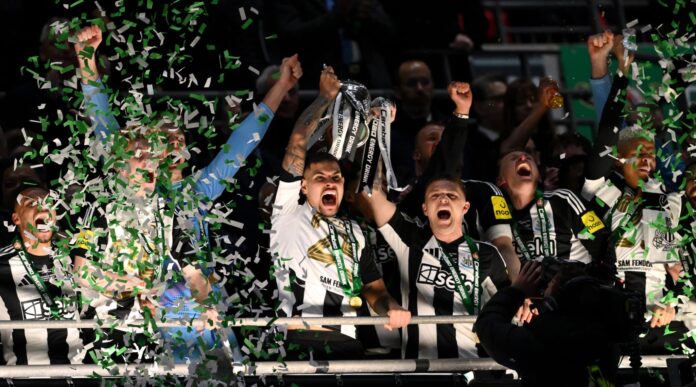 Bruno Guimaraes and Kieran Trippier of Newcastle United lift the Carabao Cup Trophy after their team's victory in the Carabao Cup Final between Premier League clubs Liverpool and Newcastle United at Wembley Stadium on March 16, 2025 in London, England.