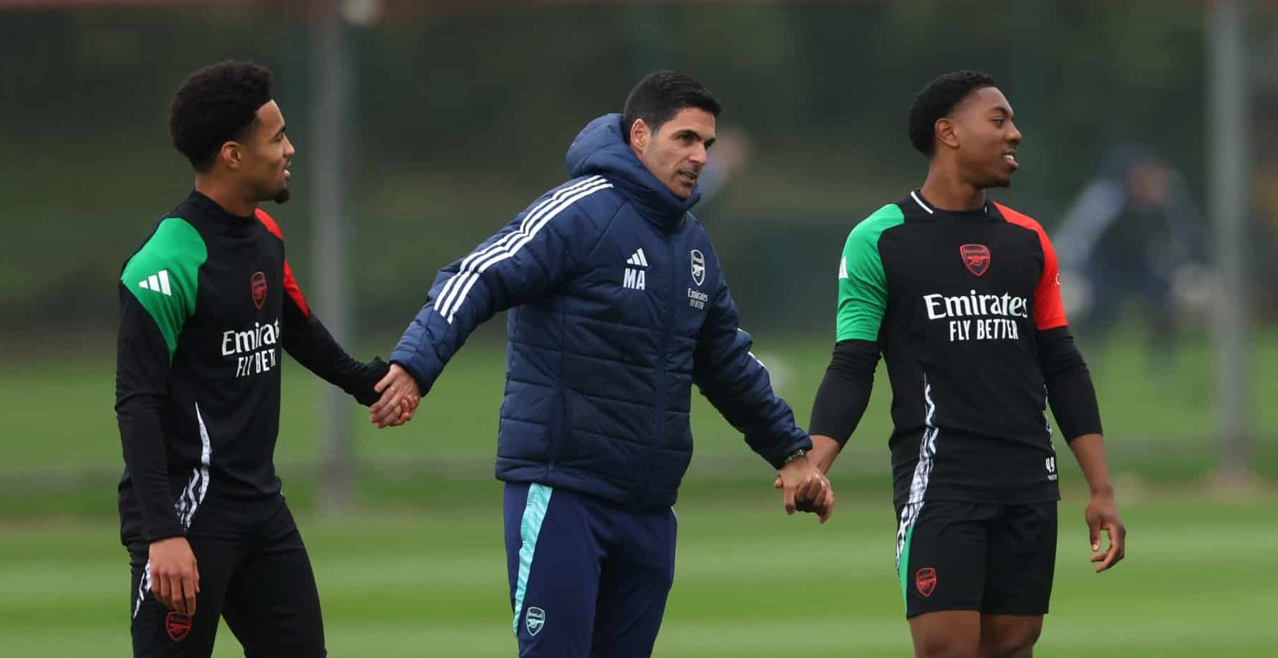 Mikel Arteta, Manager of Arsenal, links hands with Ethan Nwaneri and Myles Lewis-Skelly of Arsenal during a training session ahead of their UEFA Champions League 2024/25 quarter final second leg match at Sobha Realty Training Centre on April 15, 2025 in London Colney, England.