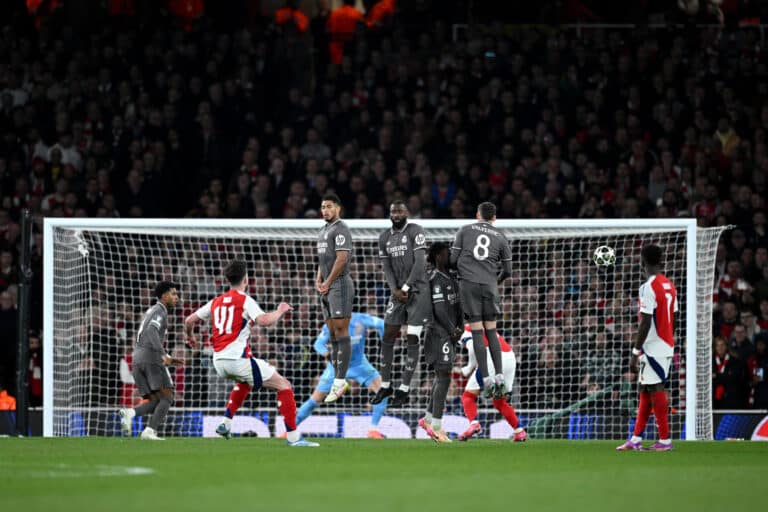 Declan Rice of Arsenal scores his team's first goal from a free kick as Jude Bellingham, Antonio Rudiger, Eduardo Camavinga and Federico Valverde of Real Madrid jump in a defensive wall during the UEFA Champions League 2024/25 Quarter Final First Leg match between Arsenal FC and Real Madrid C.F. at Emirates Stadium on April 08, 2025 in London, England.