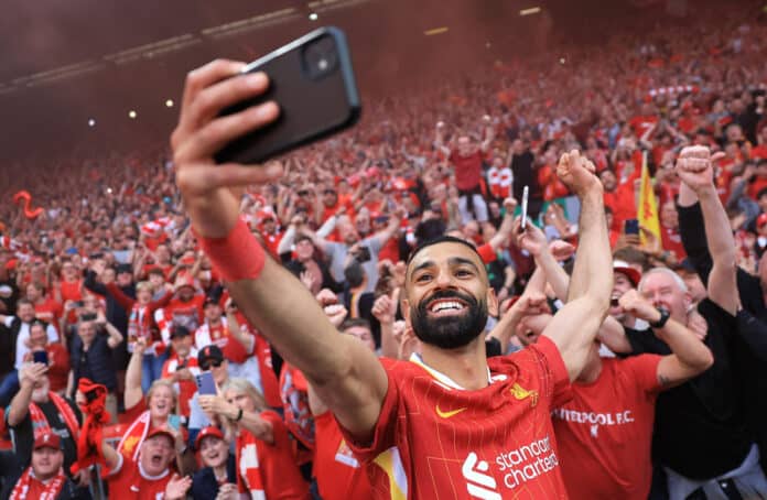 Liverpool player Mo Salah takes a selfie with the fans, as they celebrate the team's victory and confirmation of winning the Premier League title after the Premier League match between Liverpool FC and Tottenham Hotspur FC at Anfield on April 27, 2025 in Liverpool, England.