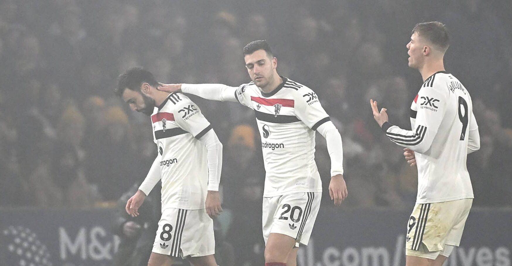 Manchester United captain Bruno Fernandes is consoled by teammate Diogo Dalot whilst leaving the pitch, after being shown a red card, during the Premier League match between Wolverhampton Wanderers FC and Manchester United FC at Molineux on December 26, 2024 in Wolverhampton, England.