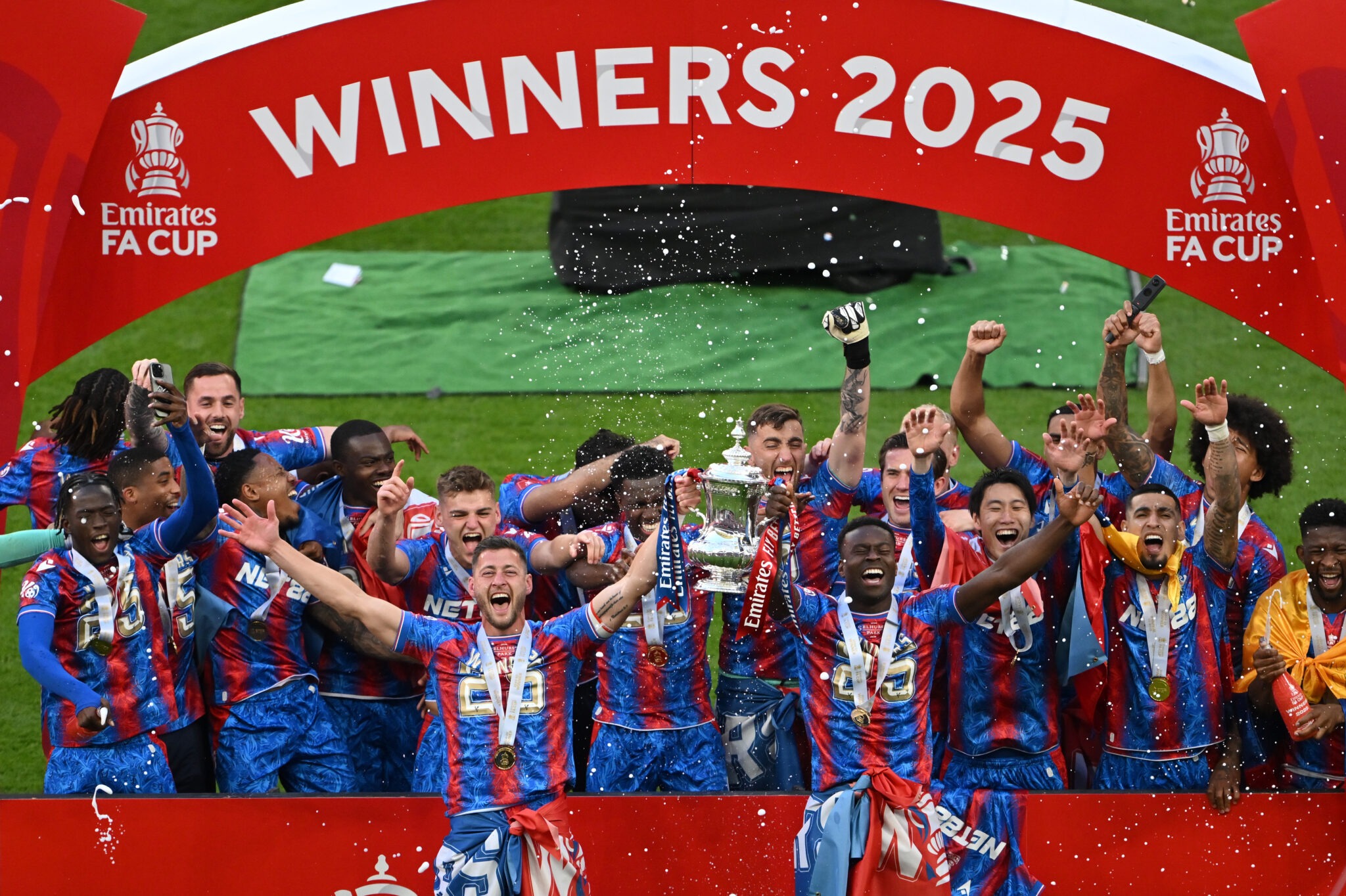 Marc Guehi and Joel Ward of Crystal Palace lift the FA Cup trophy after their team's victory in the Emirates FA Cup Final match between Crystal Palace and Manchester City at Wembley Stadium on May 17, 2025 in London, England.