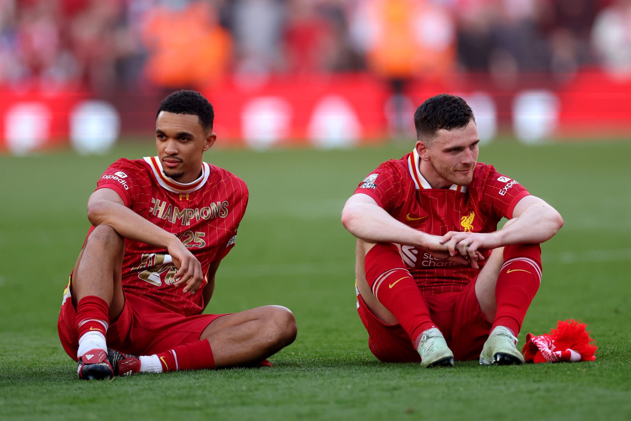Trent Alexander-Arnold and Andrew Robertson of Liverpool look on, as they celebrate the team's victory and confirmation of winning the Premier League title after the Premier League match between Liverpool FC and Tottenham Hotspur FC at Anfield on April 27, 2025 in Liverpool, England.