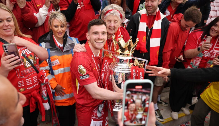 Andy Robertson of Liverpool poses for a photograph alongside a fan with the Premier League trophy, as Liverpool are crowned the Champions of the Premier League, following the Premier League match between Liverpool FC and Crystal Palace FC at Anfield on May 25, 2025 in Liverpool, England.