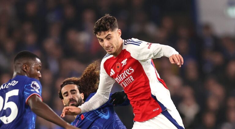 Arsenal player Kai Havertz runs with the ball whilst under pressure from Moises Caicedo and Marc Cucurella during the Premier League match between Chelsea FC and Arsenal FC at Stamford Bridge on November 10, 2024 in London, England.