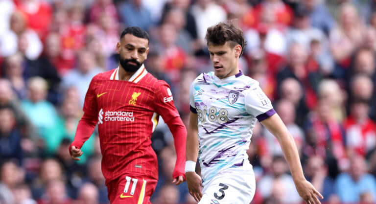 Liverpool - Milos Kerkez of AFC Bournemouth runs with the ball while under pressure from Mohamed Salah of Liverpool during the Premier League match between Liverpool FC and AFC Bournemouth at Anfield on September 21, 2024 in Liverpool, England.