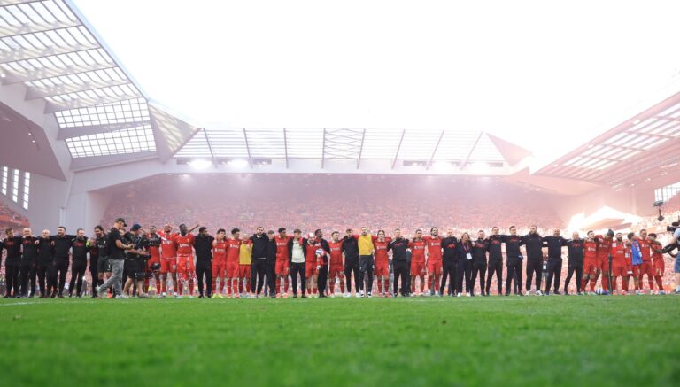 Liverpool players Alisson Becker, Ryan Gravenberch, Cody Gakpo, Ibrahima Konate, Joe Gomez, Wataru Endo, Curtis Jones, Kostas Tsimikas, Harvey Davies, Tyler Morton, Harvey Elliott, Diogo Jota, Caoimhin Kelleher, Federico Chiesa, Trent Alexander-Arnold, Dominik Szoboszlai, Johnny Heitinga, Assistant Manager of Liverpool, Vitezslav Jaros, Arne Slot, Manger of Liverpool, Sipke Hulshoff, assistant Manager of Liverpool, Andrew Robertson, Virgil van Dijk, Mohamed Salah, Alexis Mac Allister, Darwin Nunez and Luis Diaz of Liverpool celebrate the team's victory and confirmation of winning the Premier League title after the Premier League match between Liverpool FC and Tottenham Hotspur FC at Anfield on April 27, 2025 in Liverpool, England.