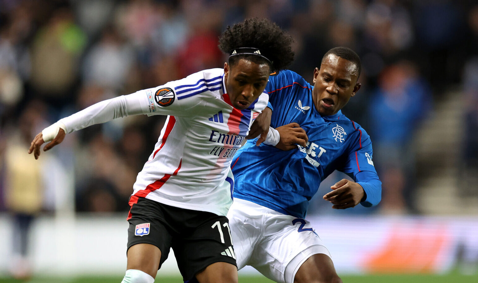 Malick Fofana of Lyon is challenged by Neraysho Kasanwirjo of Rangers FC during the UEFA Europa League 2024/25 League Phase MD2 match between Rangers FC and Olympique Lyonnais at Ibrox Stadium on October 03, 2024 in Glasgow, Scotland.