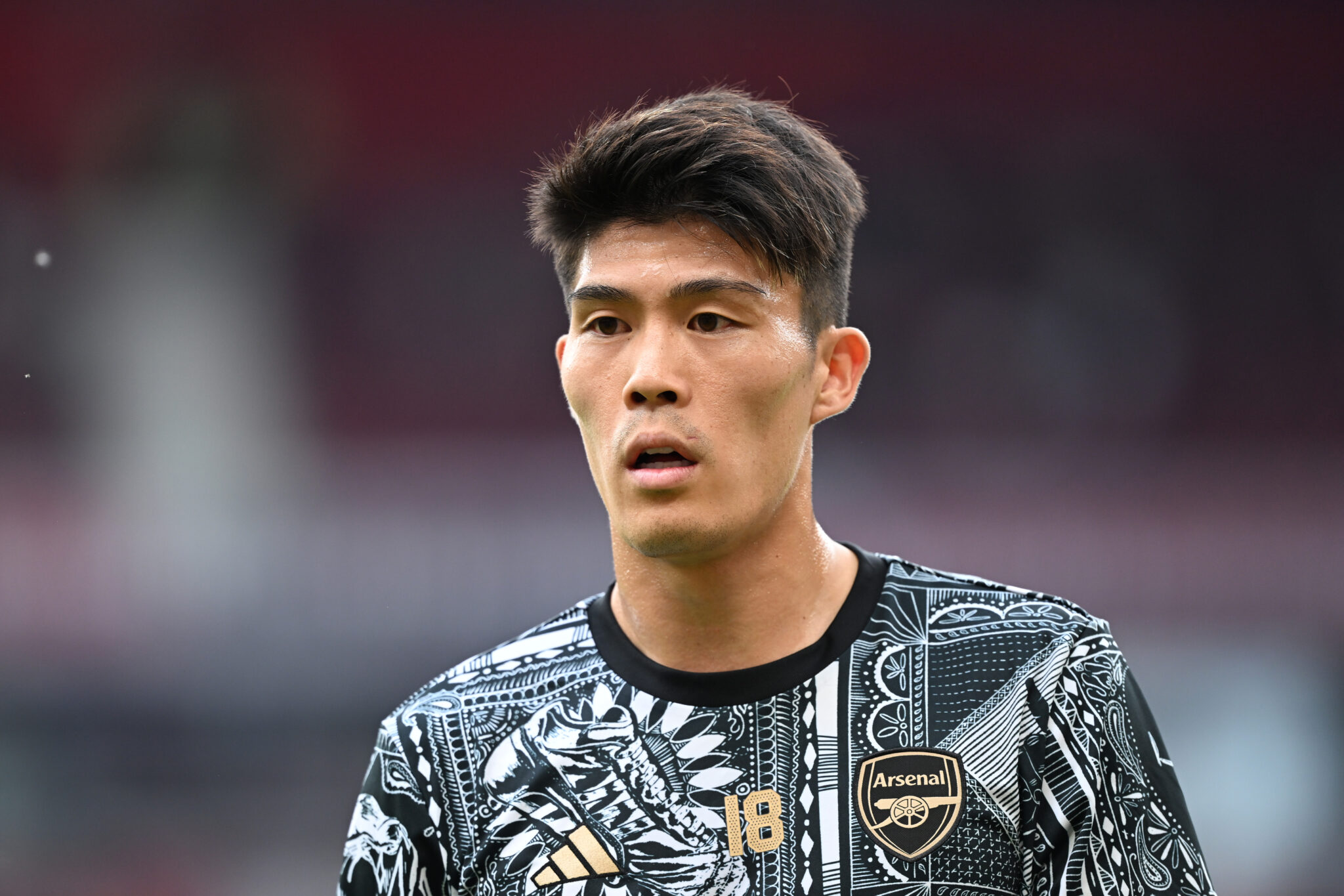 Takehiro Tomiyasu of Arsenal looks on as he warms up prior to the Premier League match between Manchester United and Arsenal FC at Old Trafford on May 12, 2024 in Manchester, England.
