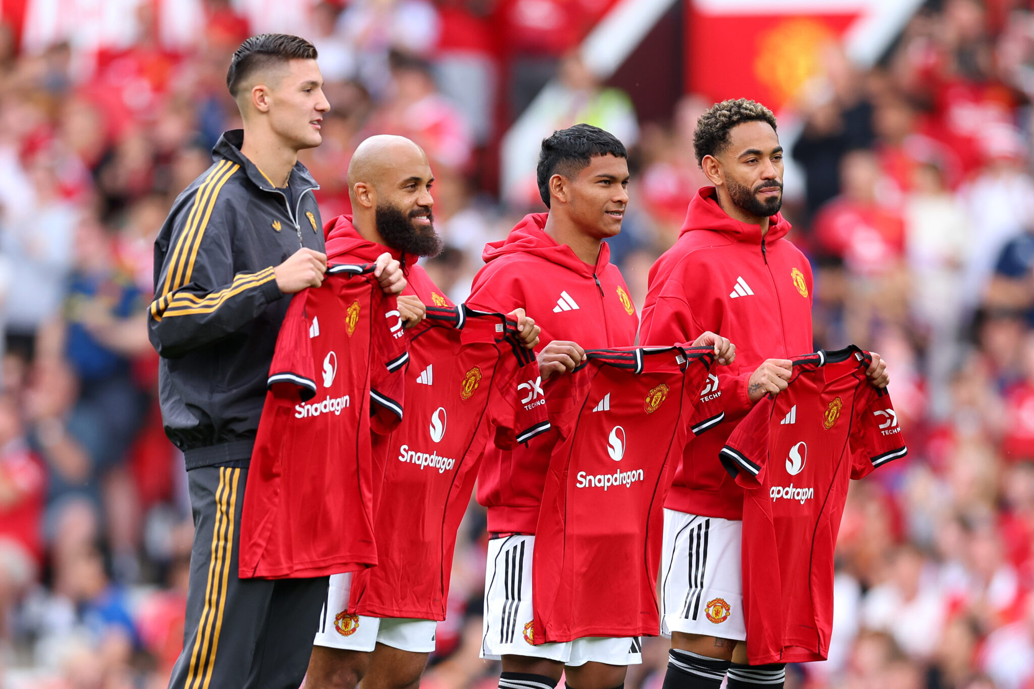 New signings Bryan Mbeumo, Benjamin Sesko, Diego Leon and Matheus Cunha of Man Utd pose for a photo while holding match shirts prior to the pre-season friendly match between Manchester United and ACF Fiorentina at Old Trafford on August 09, 2025 in Manchester, England.