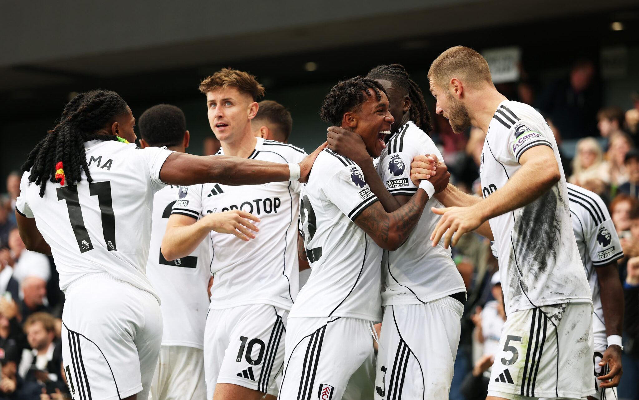 Fulham winger Kevin celebrates the team's first goal scored from an own goal by Gabriel Gudmundsson of Leeds United (not pictured) with teammate, Calvin Bassey and Joachim Andersen during the Premier League match between Fulham and Leeds United at Craven Cottage on September 13, 2025 in London, England.