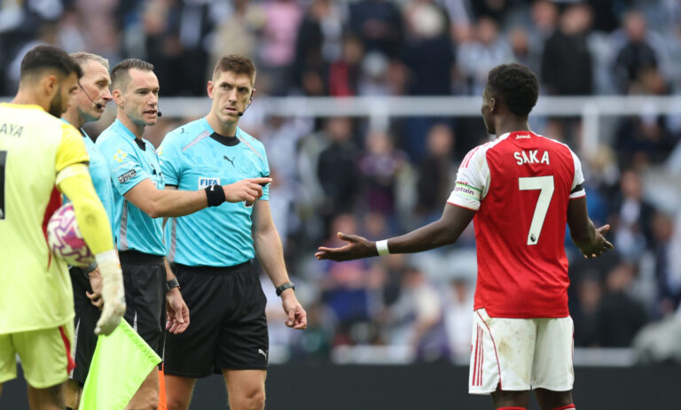 Bukayo Saka of Arsenal speaks with referee Jarred Gillett at half time during the Premier League match between Newcastle United and Arsenal at St James' Park on September 28, 2025 in Newcastle upon Tyne, England.