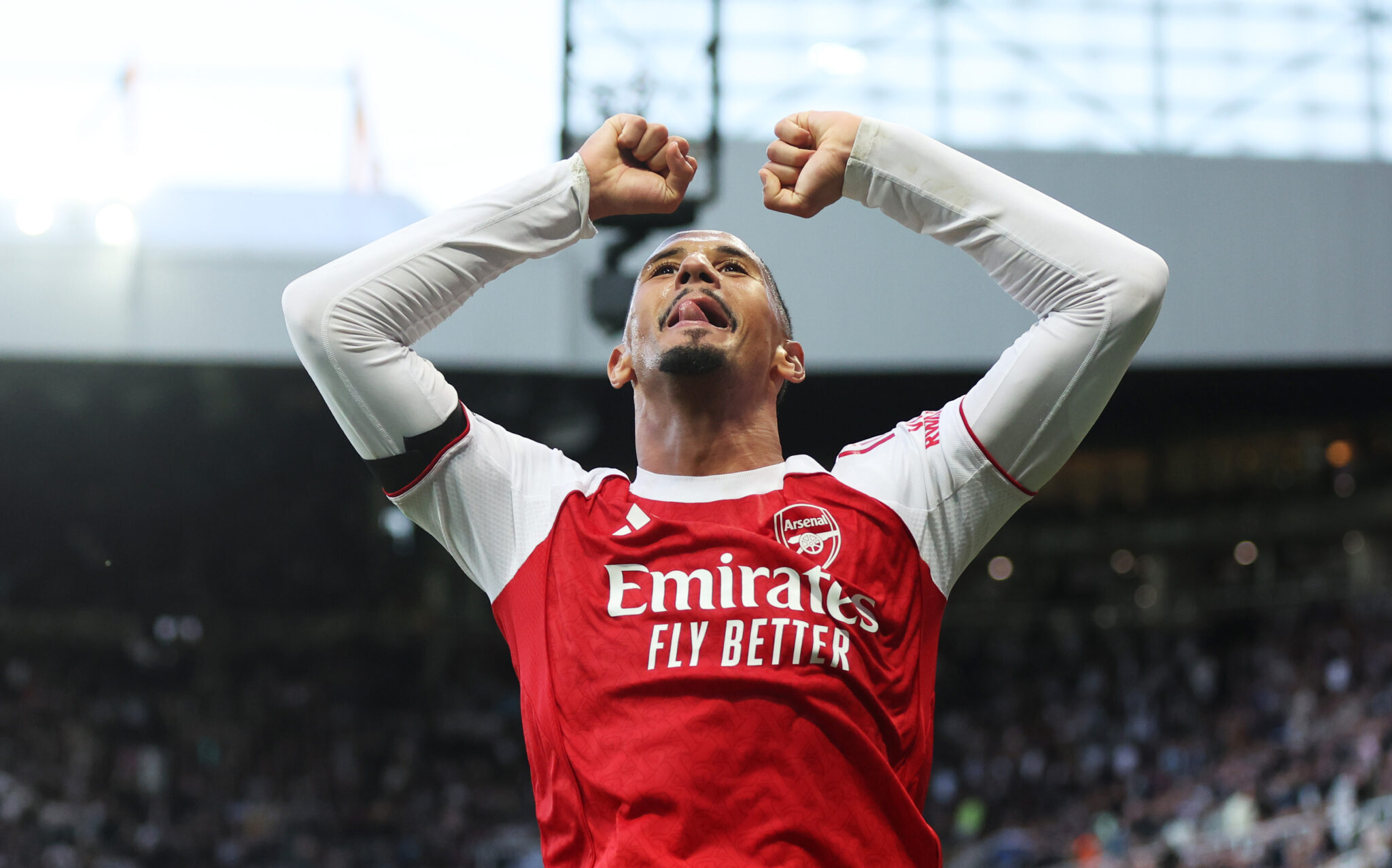 William Saliba of Arsenal celebrates with fans after teammate Gabriel (not pictured) scored his side's second goal during the Premier League match between Newcastle United and Arsenal at St James' Park on September 28, 2025 in Newcastle upon Tyne, England.