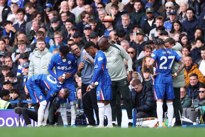 Liam Rosenior, Manager of Chelsea, speaks with Andrey Santos and Estevao of Chelsea during the Premier League match between Chelsea and Manchester City at Stamford Bridge on April 12, 2026 in London, England.