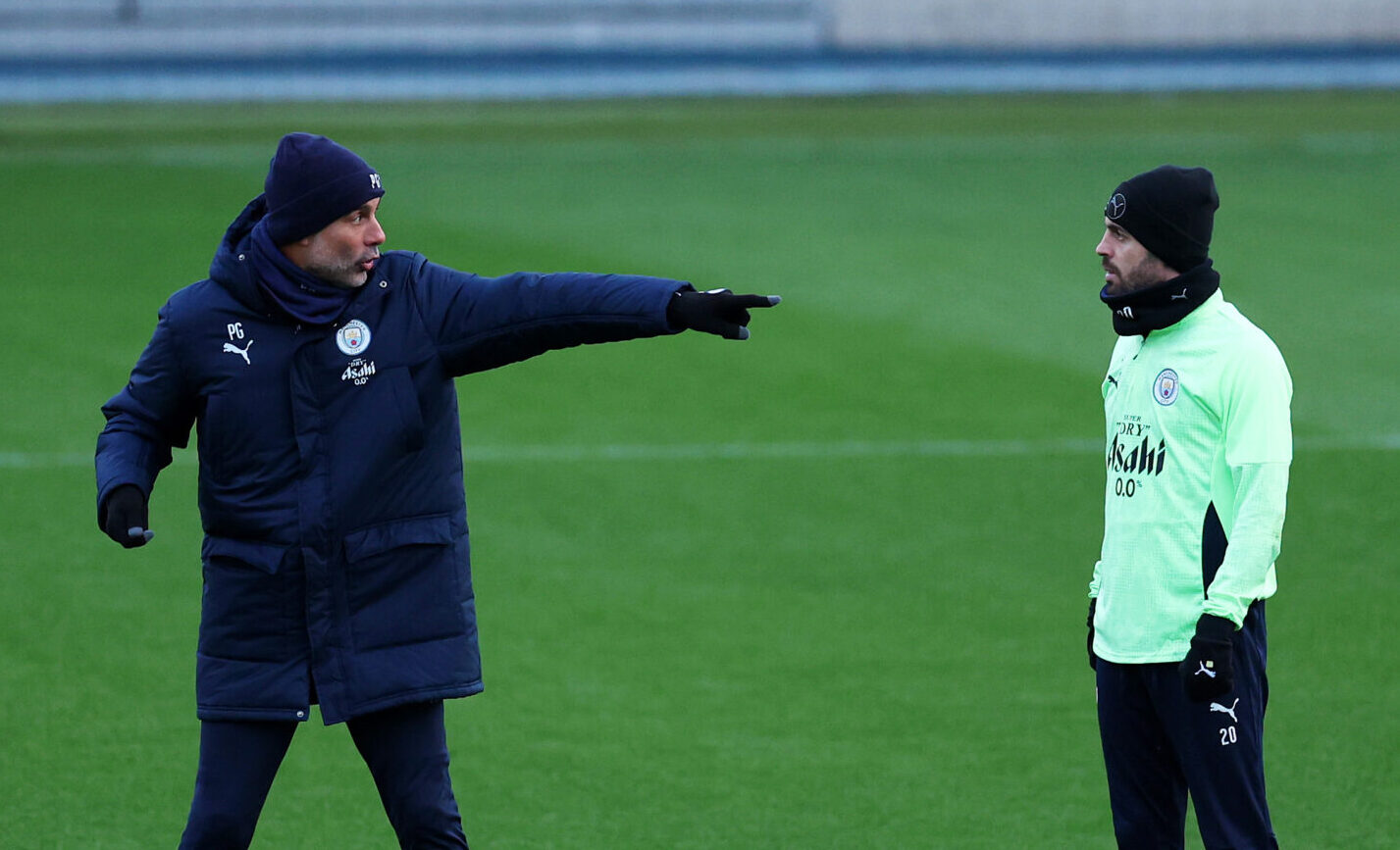 Pep Guardiola, Manager of Man City, speaks with Bernardo Silva of Manchester City during a Manchester City Training Session at Manchester City Football Academy on November 24, 2025 in Manchester, England.