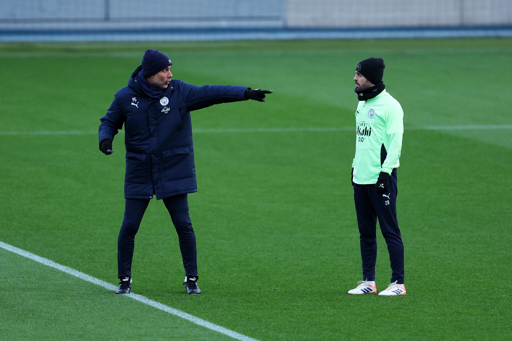 Pep Guardiola, Manager of Man City, speaks with Bernardo Silva of Manchester City during a Manchester City Training Session at Manchester City Football Academy on November 24, 2025 in Manchester, England.
