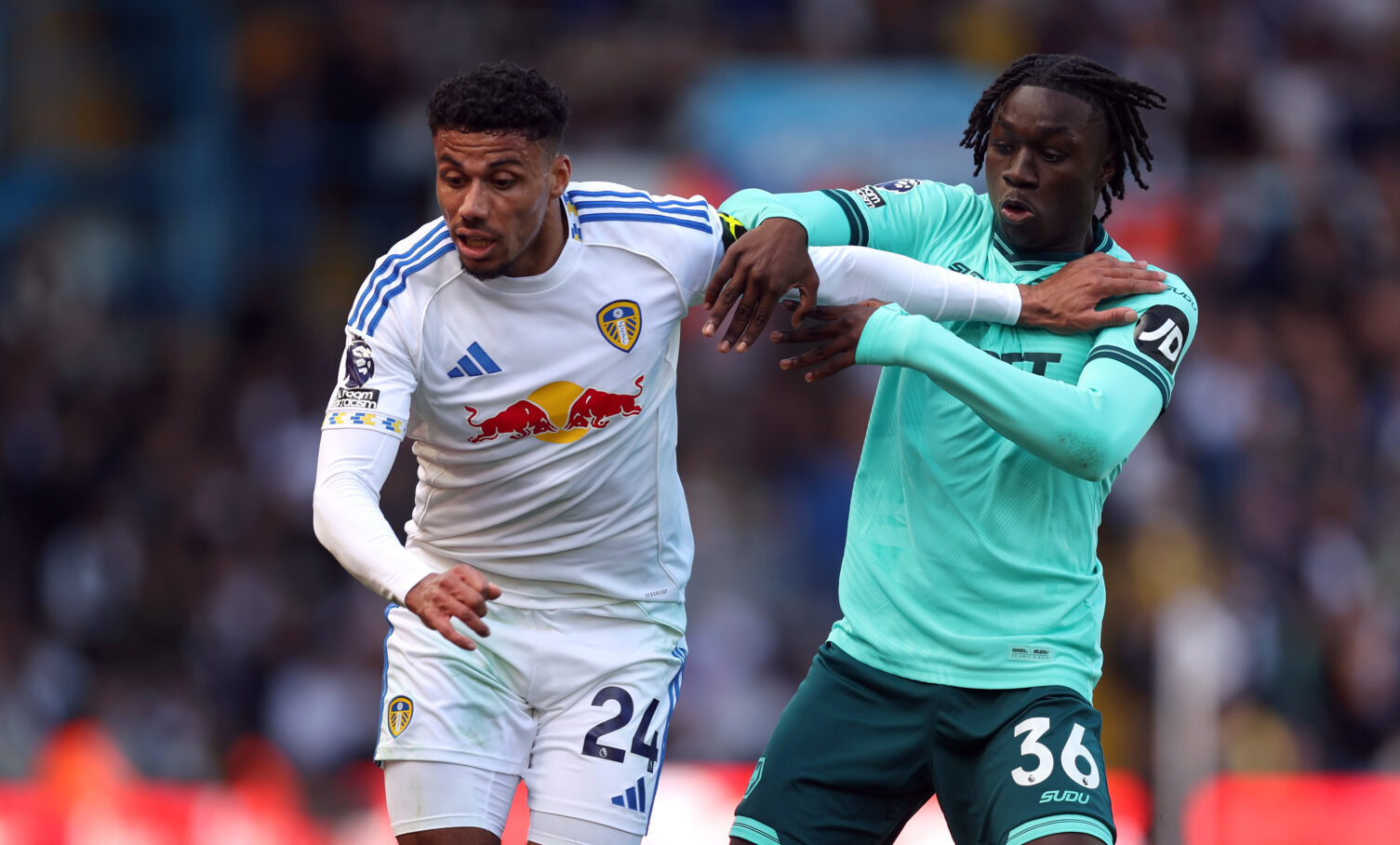 James Justin of Leeds United is challenged by Mateus Mane of Wolverhampton Wanderers during the Premier League match between Leeds United and Wolverhampton Wanderers at Elland Road on April 18, 2026 in Leeds, England.
