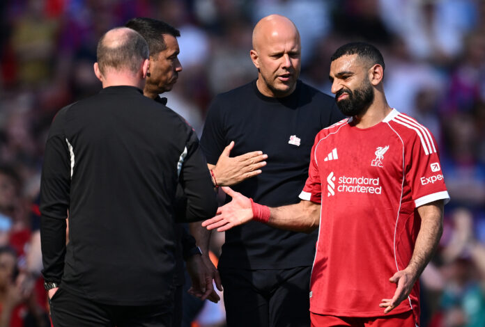 Mo Salah of Liverpool reacts with Arne Slot, Manager of Liverpool, after being substituted off during the Premier League match between Liverpool and Crystal Palace at Anfield on April 25, 2026 in Liverpool, England.