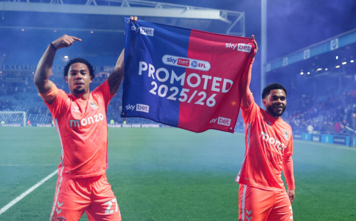 Milan van Ewijk and Jay Dasilva of Coventry City celebrate their team's promotion to the Premier League following the Sky Bet Championship match between Blackburn Rovers and Coventry City at Ewood Park on April 17, 2026 in Blackburn, England.