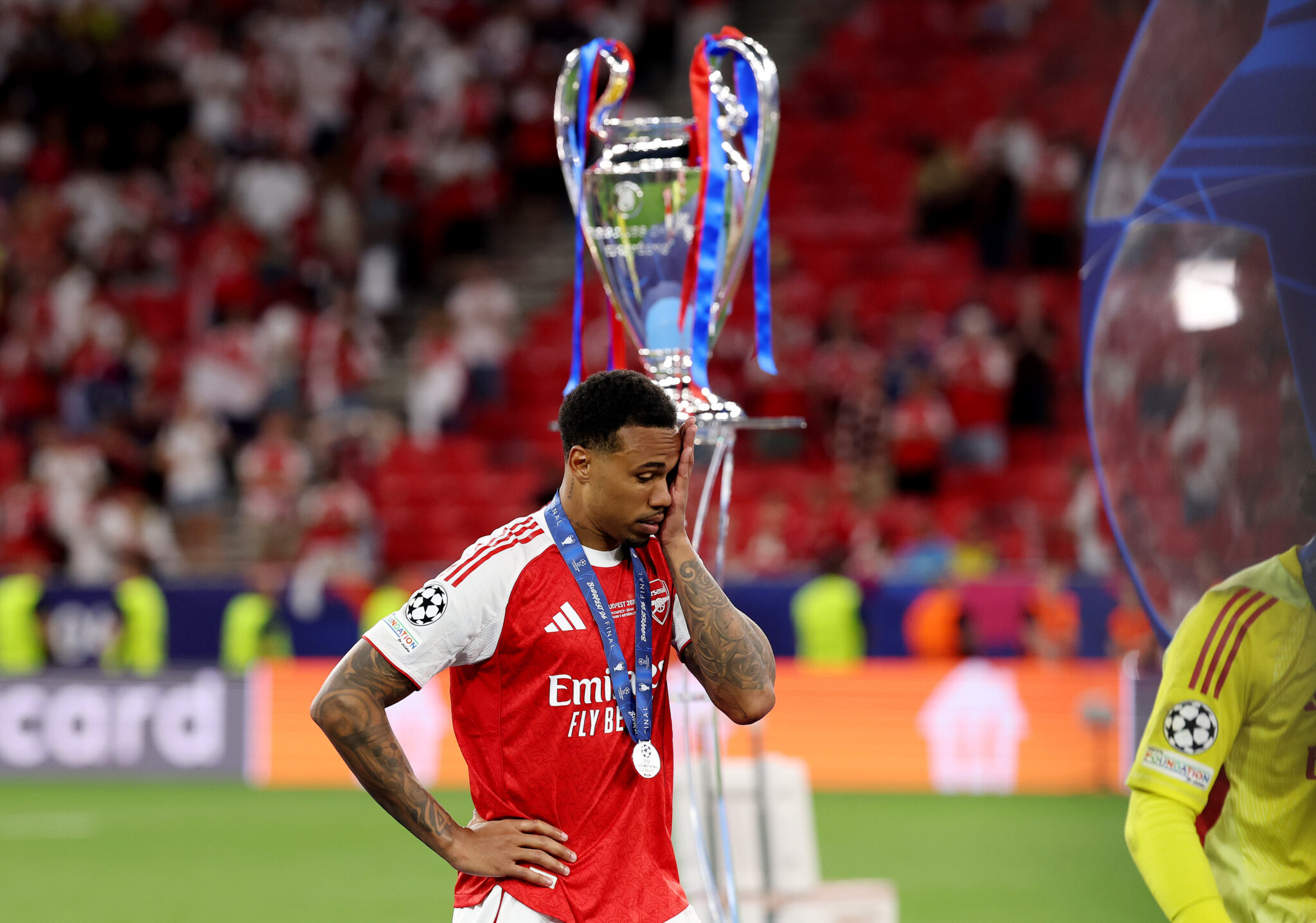 Gabriel of Arsenal looks dejected as he walks past the UEFA Champions League trophy following the UEFA Champions League Final 2026 match between Paris Saint-Germain and Arsenal FC at Puskas Arena on May 30, 2026 in Budapest, Hungary.