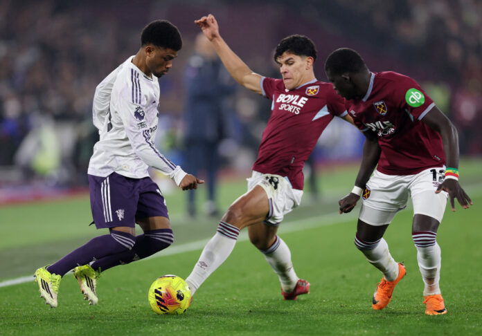 Man Utd player Amad Diallo is challenged by Mateus Fernandes and El Hadji Malick Diouf of West Ham United during the Premier League match between West Ham United and Manchester United at London Stadium on February 10, 2026 in London, England.