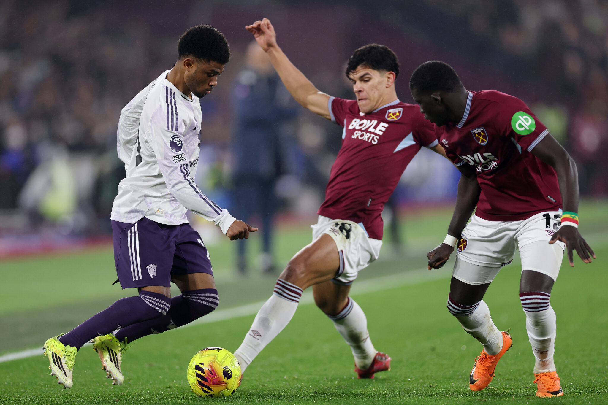 Man Utd player Amad Diallo is challenged by Mateus Fernandes and El Hadji Malick Diouf of West Ham United during the Premier League match between West Ham United and Manchester United at London Stadium on February 10, 2026 in London, England.