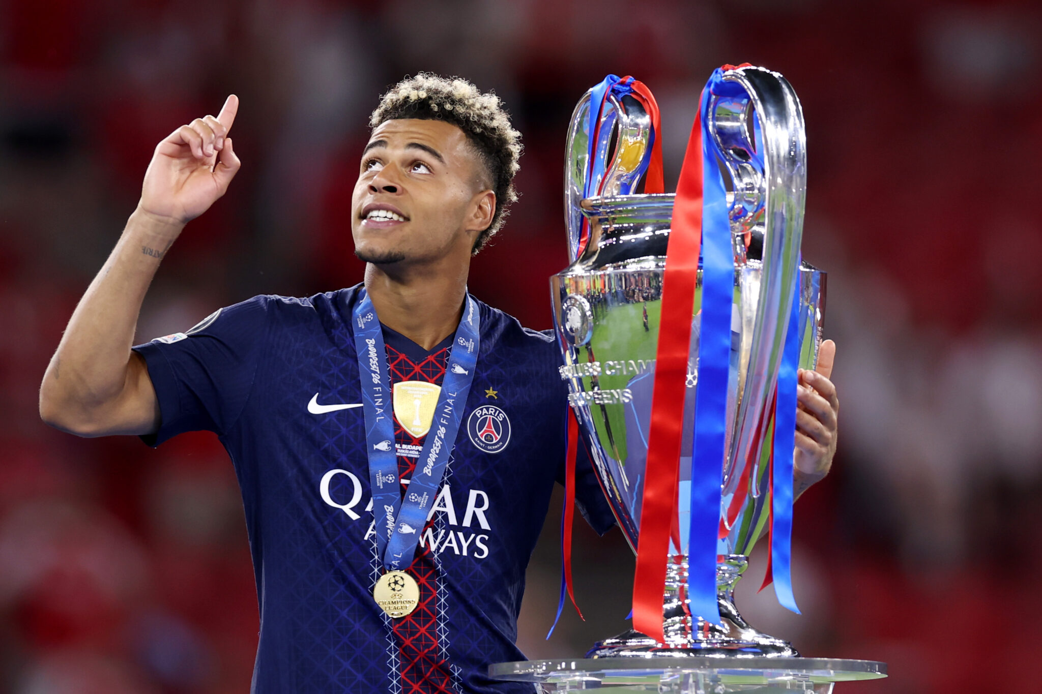 PSG player Desire Doue celebrates with the UEFA Champions League trophy as he collects his winners medal after his team's victory in the UEFA Champions League Final 2026 match between Paris Saint-Germain and Arsenal FC at Puskas Arena on May 30, 2026 in Budapest, Hungary.