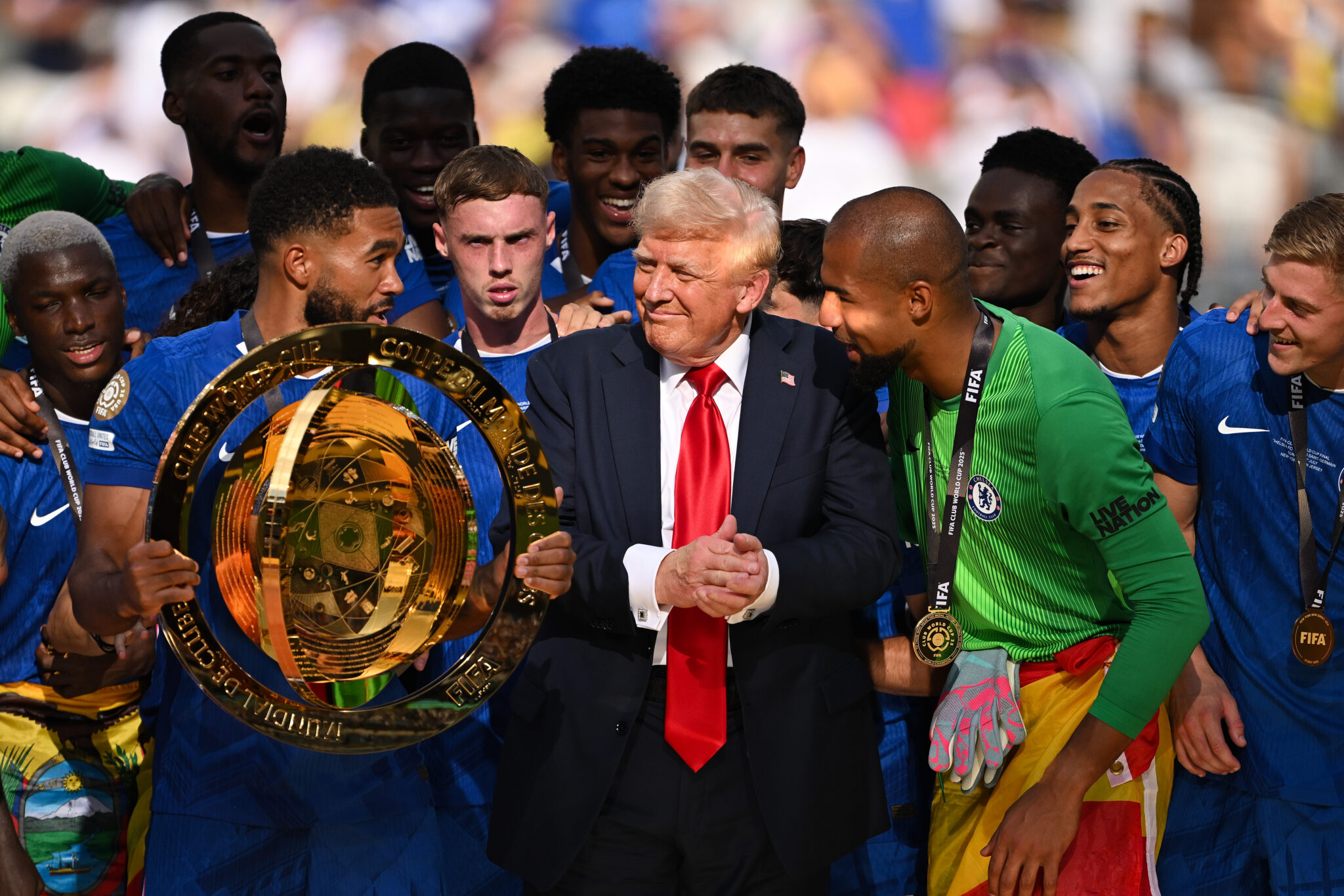 U.S. President Donald Trump interacts with Reece James #24 of Chelsea FC as he holds the FIFA Club World Cup trophy following the FIFA Club World Cup 2025 Final match between Chelsea FC and Paris Saint-Germain at MetLife Stadium on July 13, 2025 in East Rutherford, New Jersey.