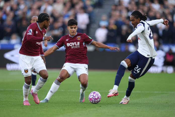 Mateus Fernandes of West Ham United with Djed Spence of Spurs during the Premier League match between West Ham United and Tottenham Hotspur at London Stadium on September 13, 2025 in London, England.